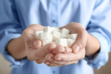 Female hands holding sugar cubes, closeup