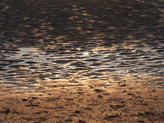 Reflection of sunset in the watery beach