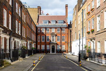 Naklejka premium Typowa scena uliczna w centralnej dzielnicy Londynu ze znanymi fasadami architektury miejskich mieszkań.