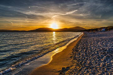 Cloudy sky over Alghero shore at sunset