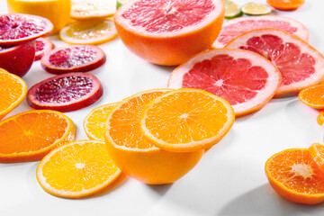 Slices of juicy citrus fruits on white background