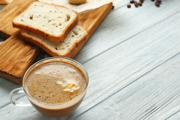 Composition with tasty butter coffee on wooden table