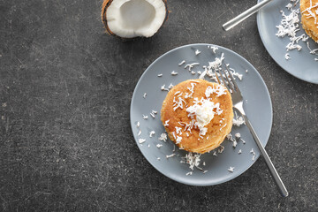 Plate with tasty homemade coconut pancakes on table