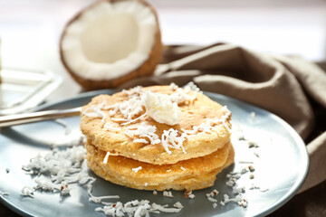 Plate with tasty homemade coconut pancakes on table