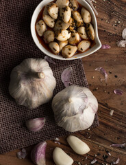 Marinated garlic, garlic cloves, herbs, rustic style, selective focus - obrazy, fototapety, plakaty