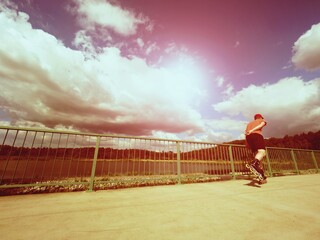 Vintage tone filter effect color style. Sportsman  with inline skates ride in summer park