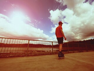 Vintage tone filter effect color style. Sportsman  with inline skates ride in summer park