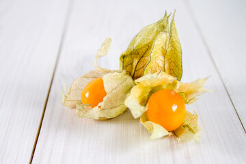 Exotic berries physalis on a white wooden table.