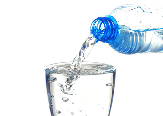 Water pouring from bottle into glass on white background