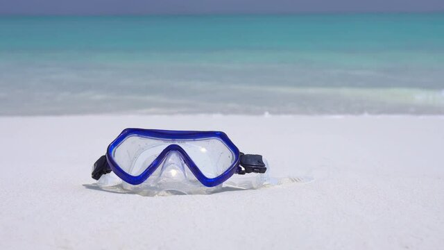 Swimming mask on white sandy seashore. Tropical vacation on beach