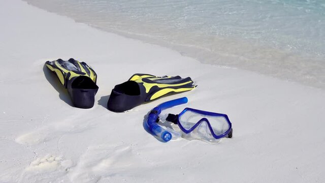 Swimming mask, fins and tube on white sandy seashore. Tropical vacation on beach. Nobody
