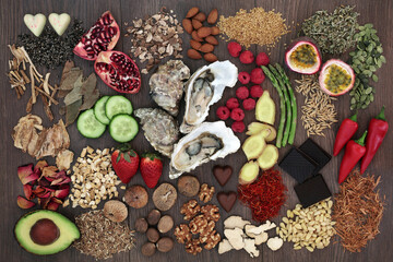 Aphrodisiac food to promote good sexual health on oak wood background.