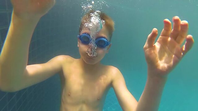 happy child swims with enjoyment under the water in the pool