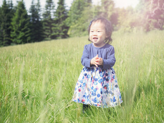 baby girl playing meadow on sunny day