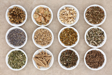 Sleeping and calming herb selection in china dishes on natural hemp paper background.