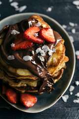 Sweet homemade pancakes with sliced strawberries and melted chocolate on the top,selective focus