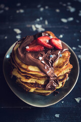 Sweet homemade pancakes with chocolate and strawberries on the top