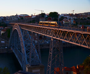 Ponte Dom Luís I during sunset, with yellow metro trams - Porto, Portugal
