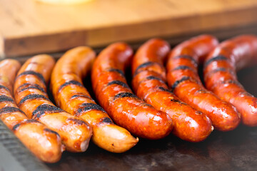 Close-up spicy sausages on the hot flat grill at the street in Prague Czech Republic. Selective focus image