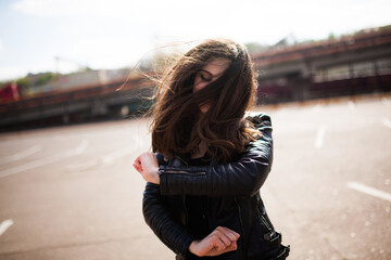 Beautiful young brunette woman is dancing on street