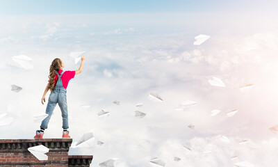 Obraz premium Concept of careless happy childhood with girl dreaming to become pilot