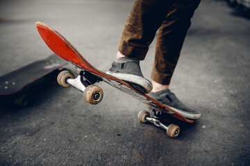 Close-up of a male guy on a skateboard doing trick kicks in shoes. The concept of doing street sports skateboarding. Monochrome and high contrast.