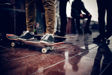 Athlete on a skateboard on the background Friends of a company of men holding their hands skateboards. Concept group of street athletes students