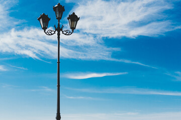 Iron lamppost on a background of blue sky