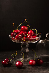 cherries and glass box over dark background