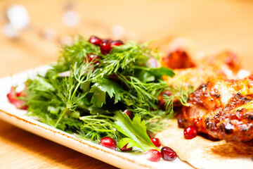 Chicken kebab with tomato sauce, herbs and pomegranate seeds.