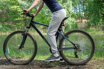 Fototapeta na wymiar Relax on a mountain bike ride along the forest path. Sports and the concept of active life in the summer. Horizontal frame