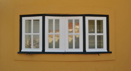 Conjunto de janelas, parede amarela com 3 janelas de 4 vidros 