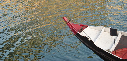 Proa vermelha, frente de um barco com ponta vermelha e branca, água do rio de fundo
