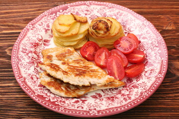 Fried turkey fillets, roasted potatoes and cherry tomato