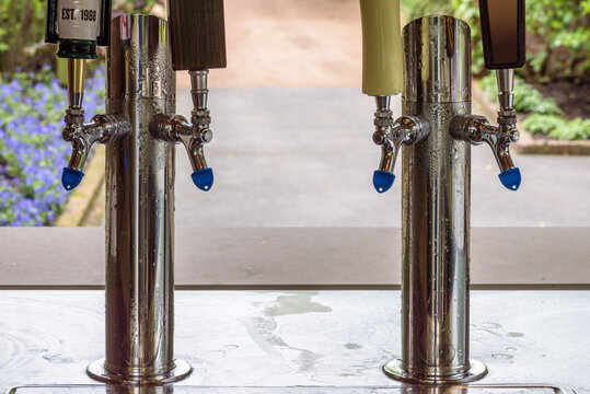 keg beer tappers and tap handles at beer kiosk at outdoor reception