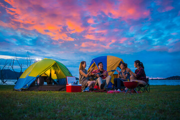 Camping of happy asian young travellers at lake, asian man and women group, relaxing, sing a song...
