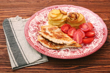 Fried turkey fillets, roasted potatoes and cherry tomato