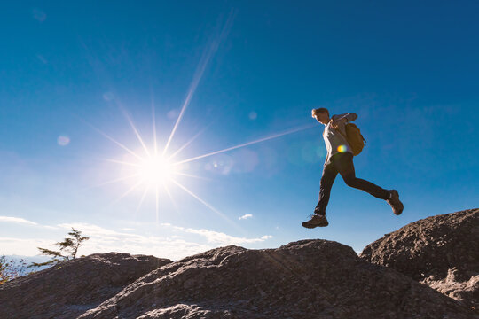 Man jumping over gap on mountain hike