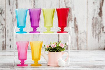 Row of Multi Colored Glasses on White Wooden Background