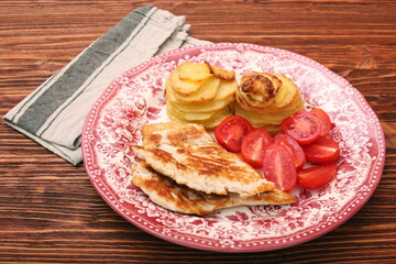 Fried turkey fillets, roasted potatoes and cherry tomato