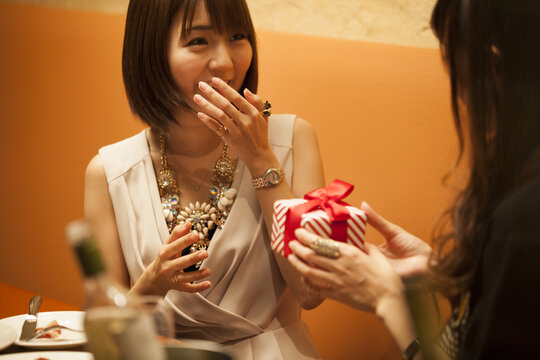 A woman gives a present to a friend