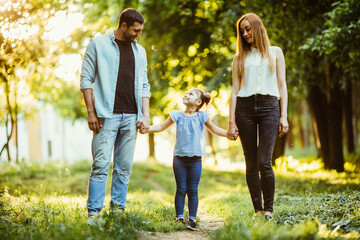 Obraz premium young family on a walk in the summer park