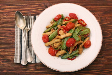 Stewed chicken breast with green bell pepper, young peas and tom