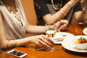 Women are eating while drinking white wine in the restaurant