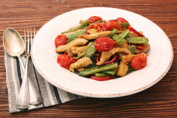 Stewed chicken breast with green bell pepper, young peas and tom