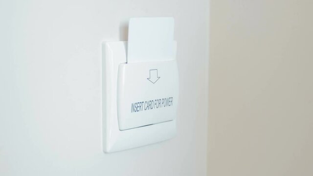 Closeup 4K footage of young woman inserting electronic key card in holder on wall