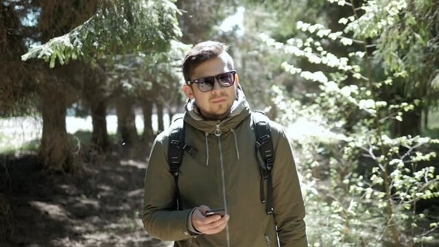 Young Man traveler viewing map in digital mobile phone in forest