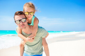 Portrait of little adorable girl and young father at tropical beach