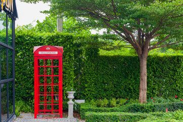 English garden with red phone booth