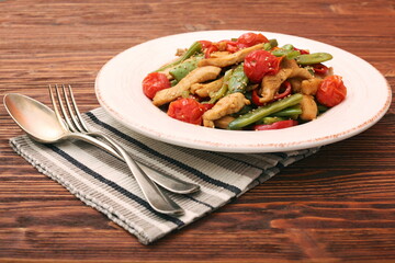 Stewed chicken breast with green bell pepper, young peas and tom